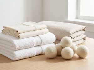 Wool dryer balls with white towels and ivory bedding
