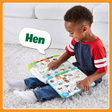 Boy pushing button in interactive book, toy says “Hen”.