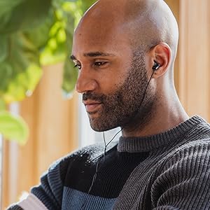 african american man listening to music wearing corded black earbuds
