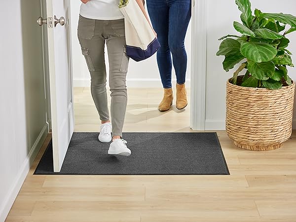 door mat at door entry. woman walking across doormat