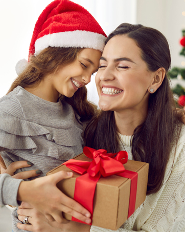 Holiday scene with wrapped kraft paper gift box featuring red bow, set against festive decorations.