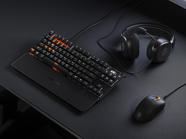 -SteelSeries desk setup with mousepad, keyboard, mouse, and headset