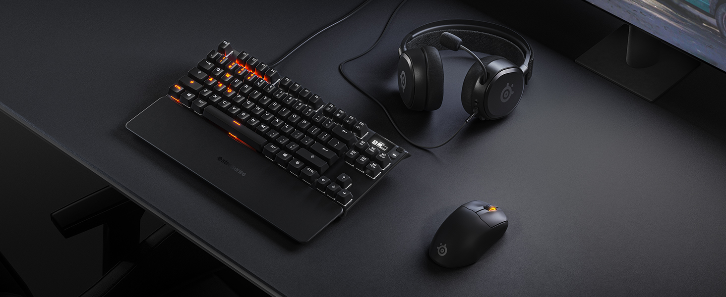 -SteelSeries desk setup with mousepad, keyboard, mouse, and headset