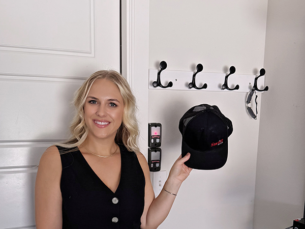 A lady is very happy that this coat rack provides convenience at the entrance for hanging hats.