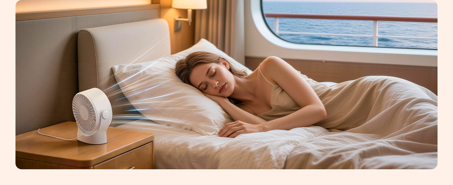 Person resting on bed in what appears to be a cruise ship cabin, with circular window visible. White bedding and wooden furnishings visible.