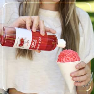 pouring cherry syrup in snow cone