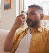 Adult using the Microlife non-contact forehead thermometer to take his temperature