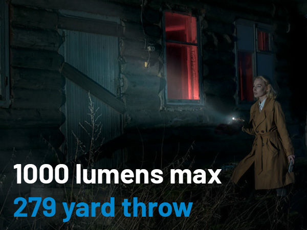 A woman with a flashlight outside at night