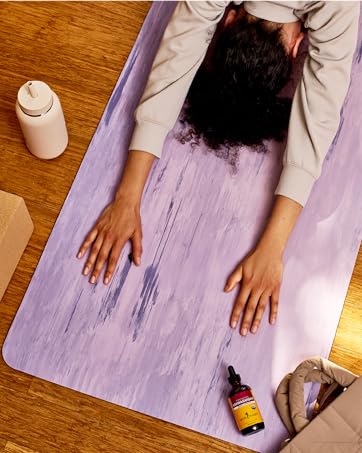 Woman in child&amp;amp;#39;s pose with a bottle of Herb Pharm&amp;amp;#39;s Ashwagandha on the mat.