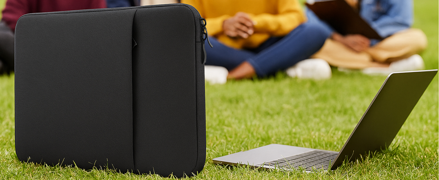 Black cushioned or padded block-shaped item on grass, with partial view of additional items in background.