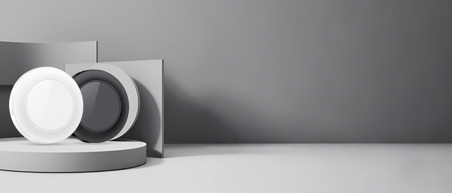 Minimalist product display with circular white and black objects on gray pedestals against a gray background. Geometric shapes create a modern, abstract composition.
