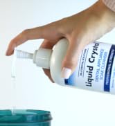 hand holding bottle of liquid crystal cleanser