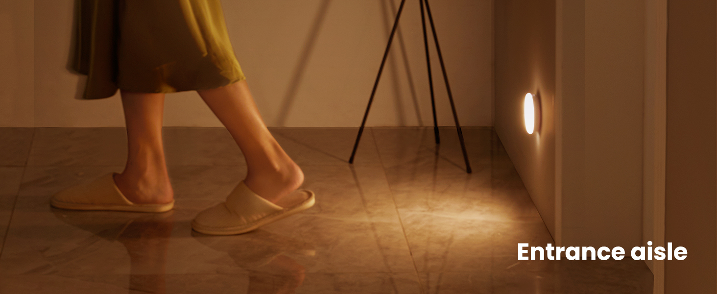 a woman standing on a tiled floor in front of a lamp.