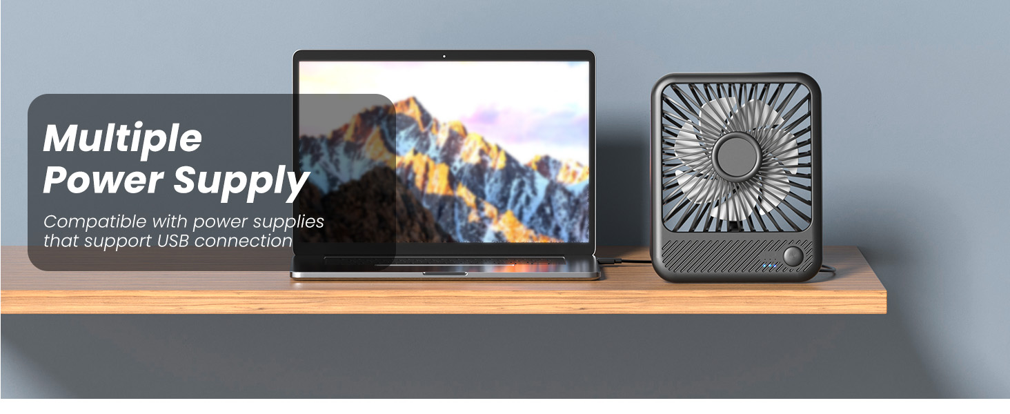 Desk setup with laptop displaying mountain scenery and square fan, text overlay reads 'Multiple Power Supply'.