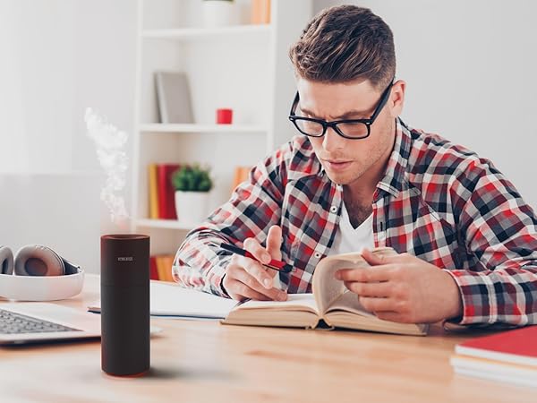 black portable air purifier sitting on desk