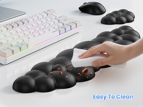 Ergonomic wrist rest with bubble-like texture being cleaned. RGB keyboard and mouse visible. Text 'Easy To Clean' shown. Black color with red illuminated spots.