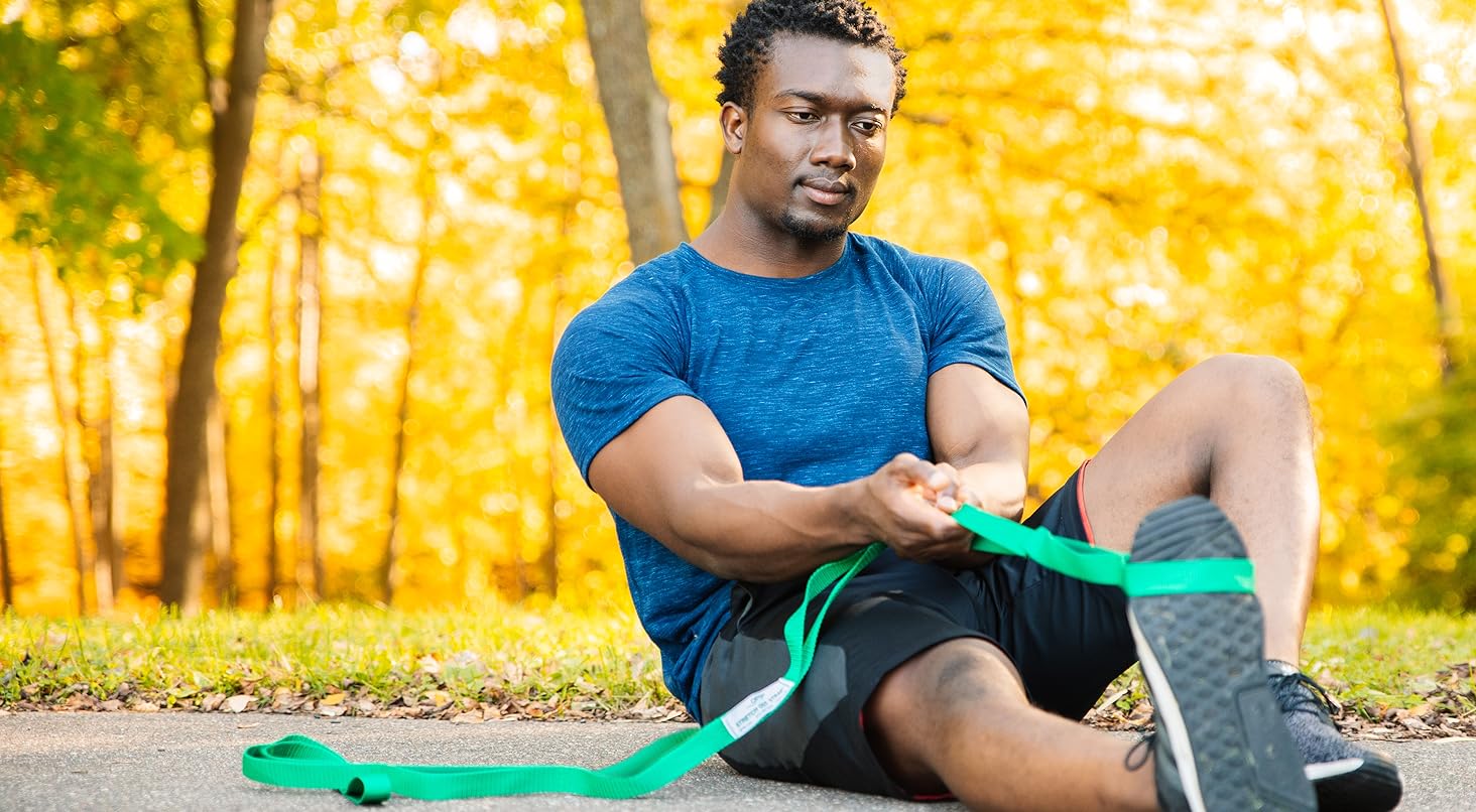 man stretching outside with a stretch out strap