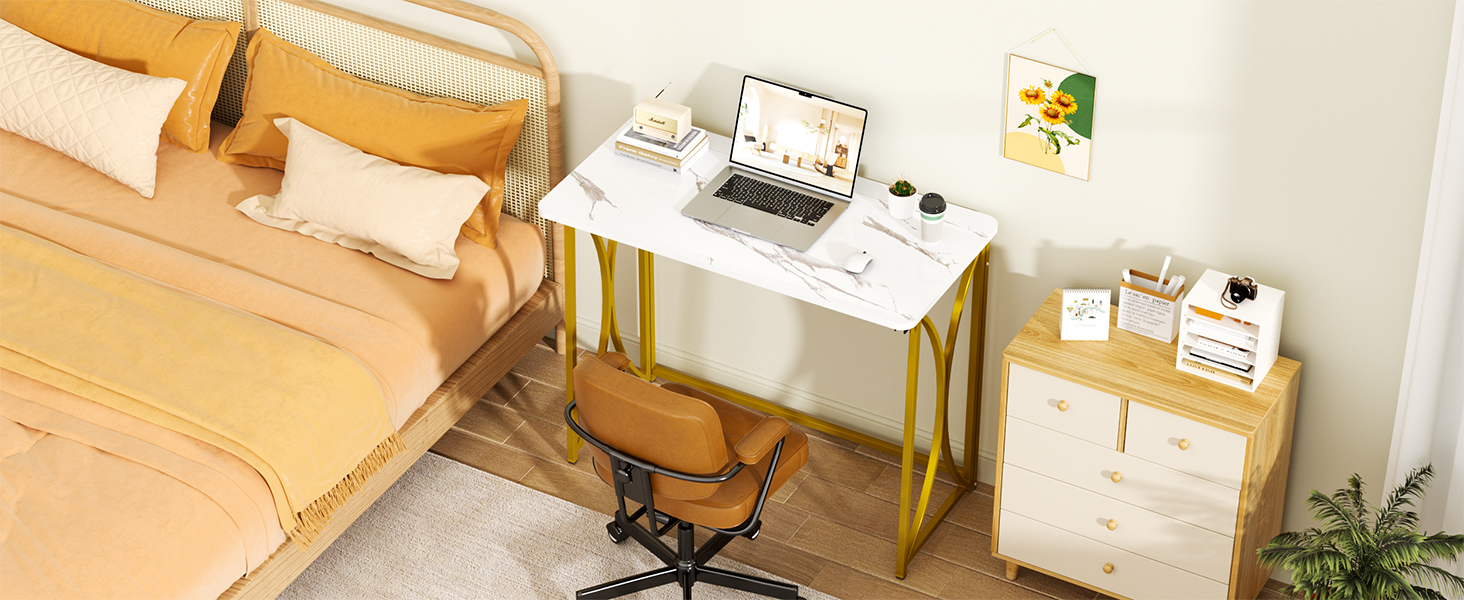 A bedroom with a bed, folding table, chair, a painting above the table and a cabinet