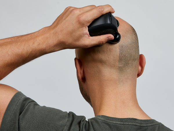 Man shaving head and face with a compact shaver