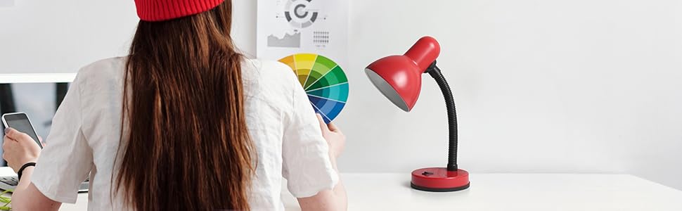 woman working at a desk with red desk lamp