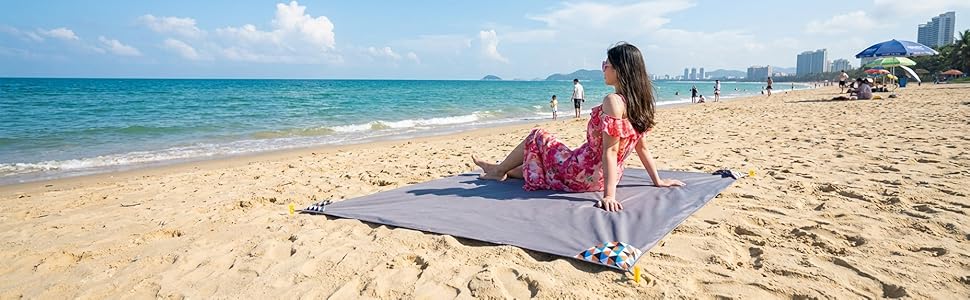 HZJOYUE sandproof beach blanket for family summer vacation, lightweight and compact travel mat.