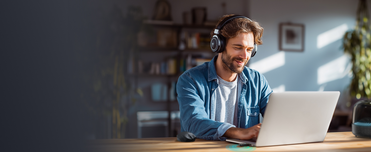 Man Wearing Headphones Using Laptop with USB WiFi and Bluetooth Adapter Plugged in
