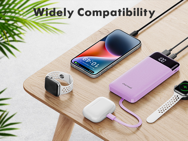 Wooden surface displaying various electronic devices including smartphones, smartwatches, and a purple power bank, showcasing wide compatibility.