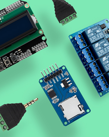 Electronic components on green background: LCD display module, relay board, SD card module, and various connectors. Circuit boards feature blue PCBs with visible components and connection points.