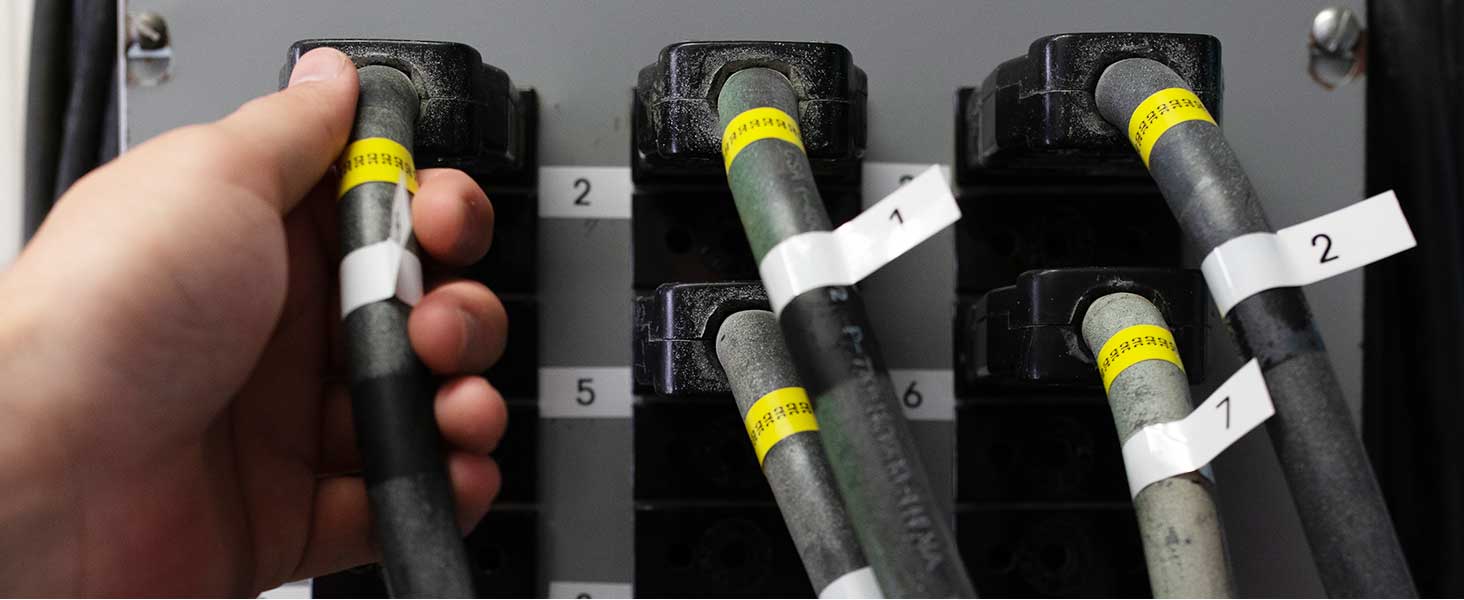 Person using TZeFX231 and TZeFX631 flexible ID labels on wires and cables