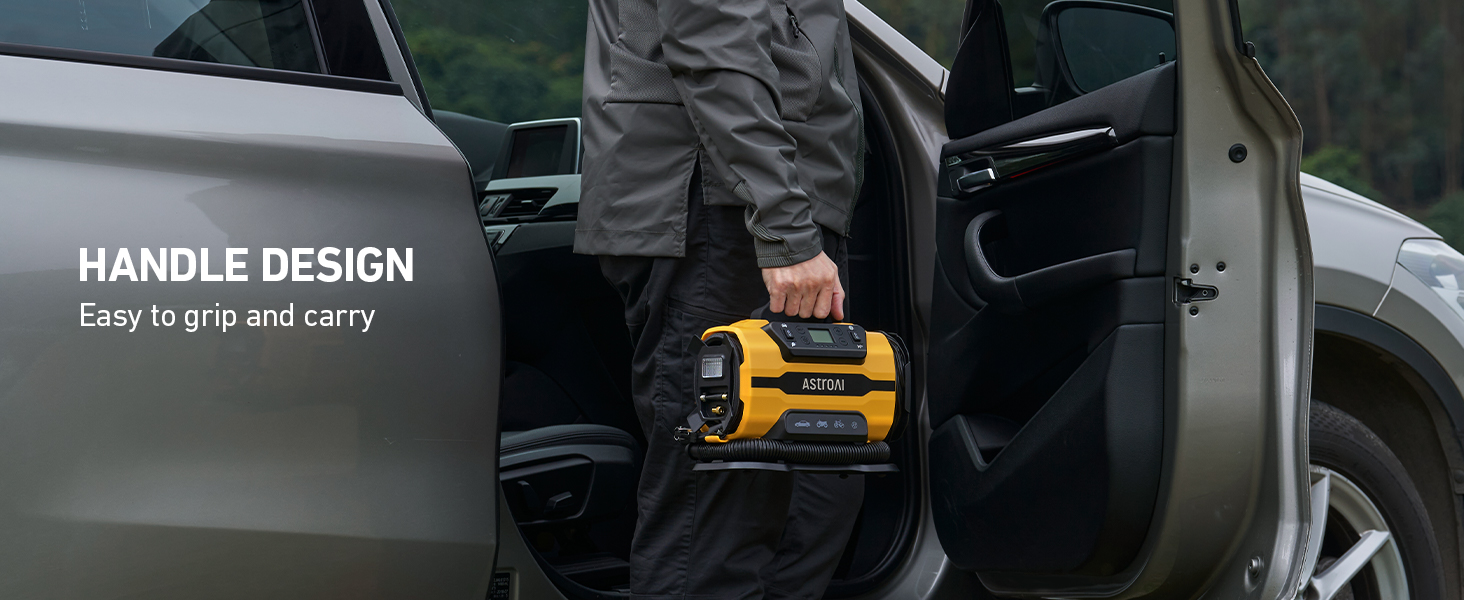 a man holding a battery in the open door of a car