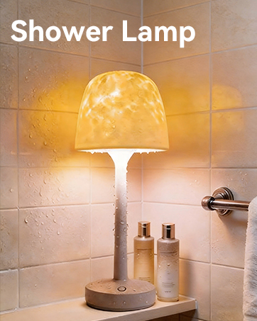 Text reads 'Shower Lamp'. Dome-shaped pendant lamp with perforated white shade emitting warm yellow light, mounted on wooden base with ceramic bath accessories below on tile wall.