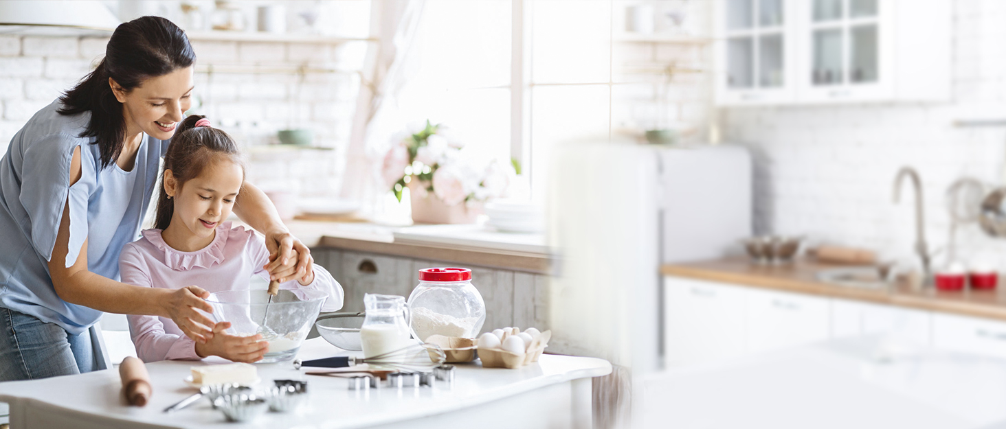 a woman is sitting at a table with a cup of coffee and a glass of milk.