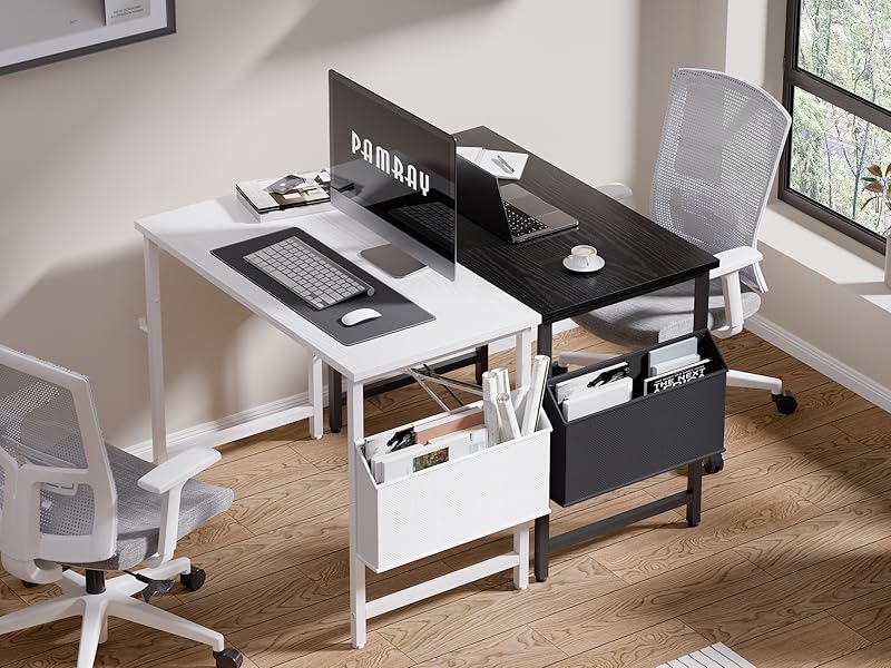 Two-person desk setup with black and white L-shaped desks, mesh office chairs, storage compartments, and a privacy divider. Desk accessories and a window visible.