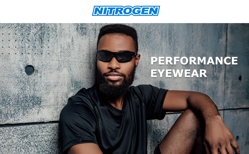 a man wearing sport sunglasses posing for the camera by the wall