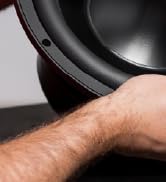partial view of a hand holding a speaker