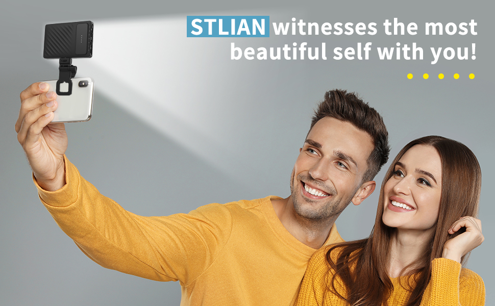 Couple using a smartphone with an attached external light or flash accessory for taking selfies.