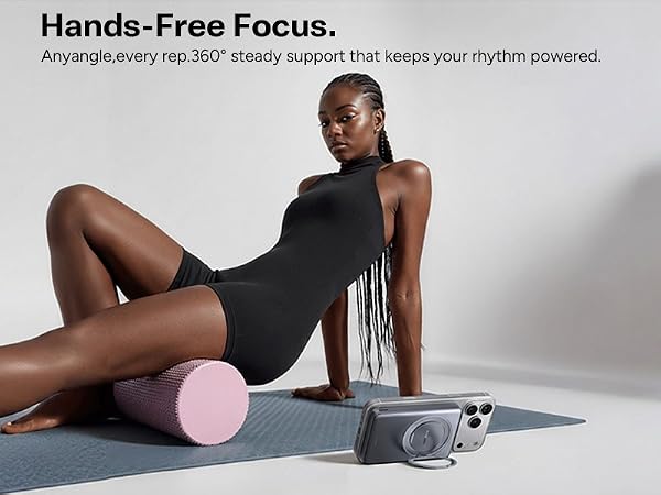 Woman on yoga mat uses phone with kickstand power bank.