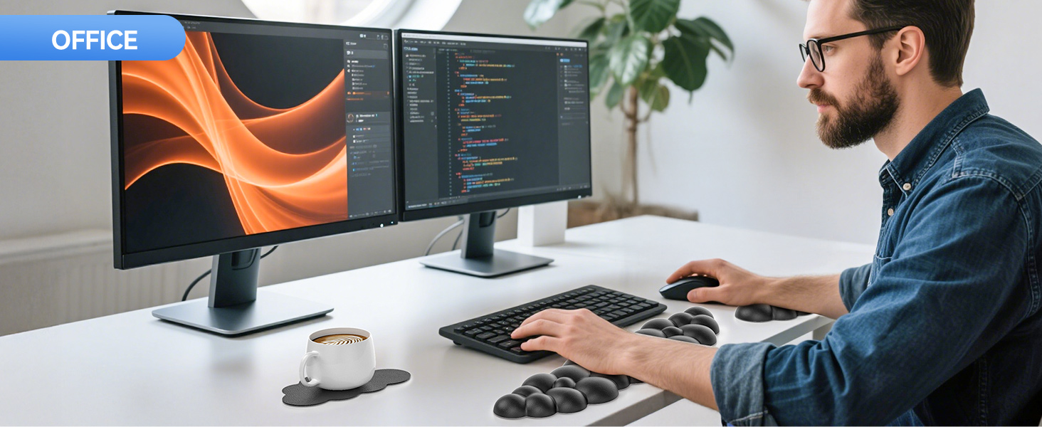 Dual-monitor setup displaying code on screens. Person typing on keyboard with coffee cup nearby. Ergonomic split keyboard and ergonomic mouse pad visible on desk.