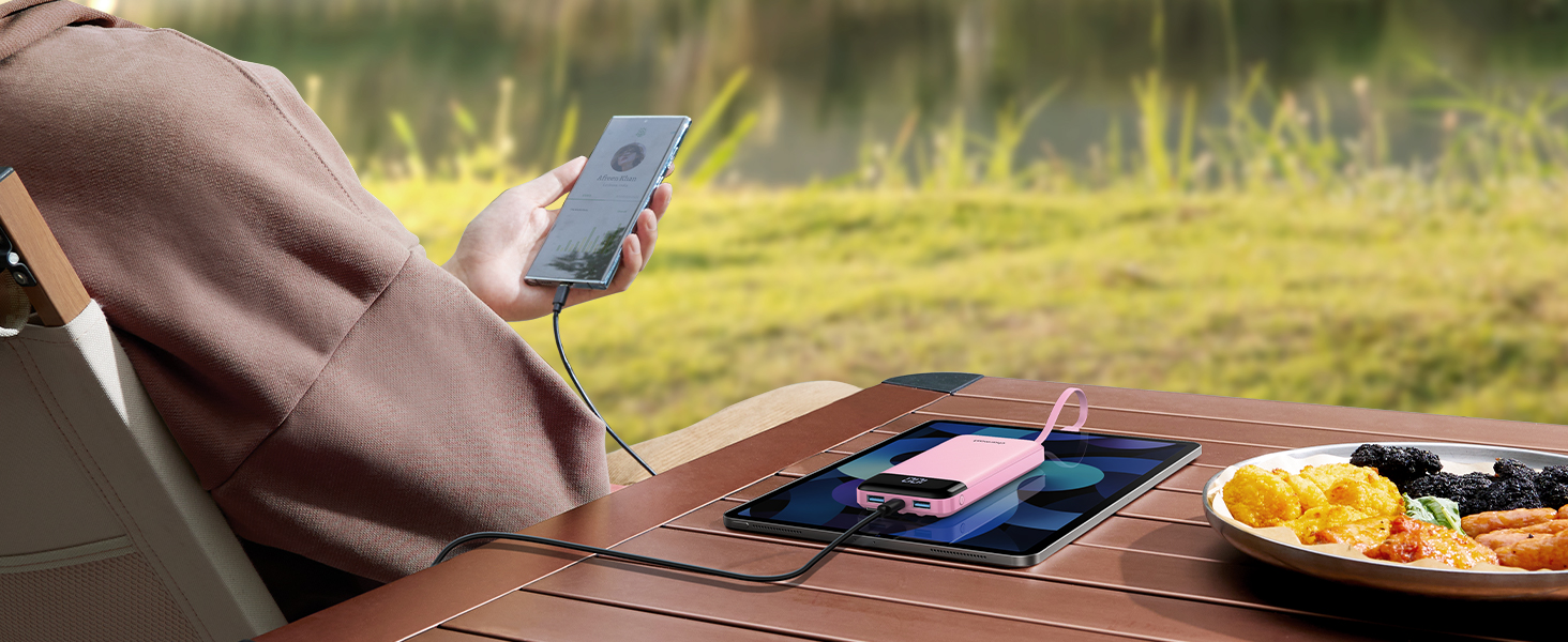 a person is using a smartphone to charge a charger on a table.