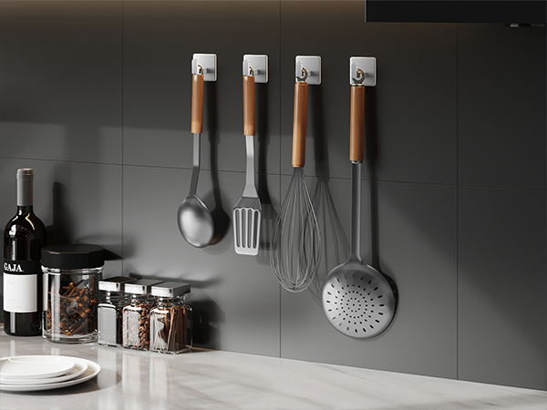 Modern kitchen counter setup with minimalist design, showing organized utensils, bottles, and cooking implements against gray wall backdrop.