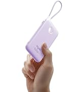 Lavender portable power bank with wrist strap. Compact rectangular design with rounded corners. Hand holding device to show size. Small circular indicator on front.