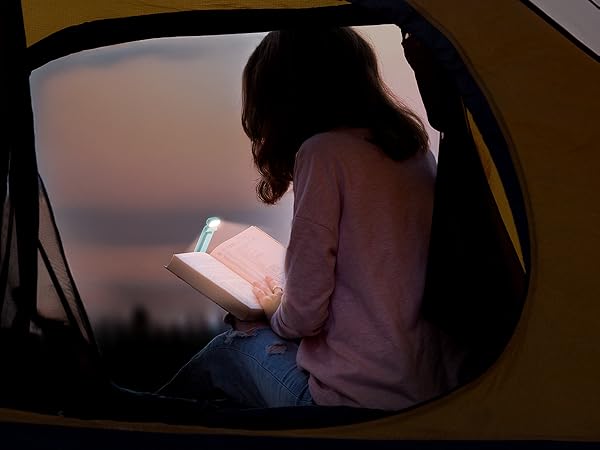 a woman sitting in a car reading a book.