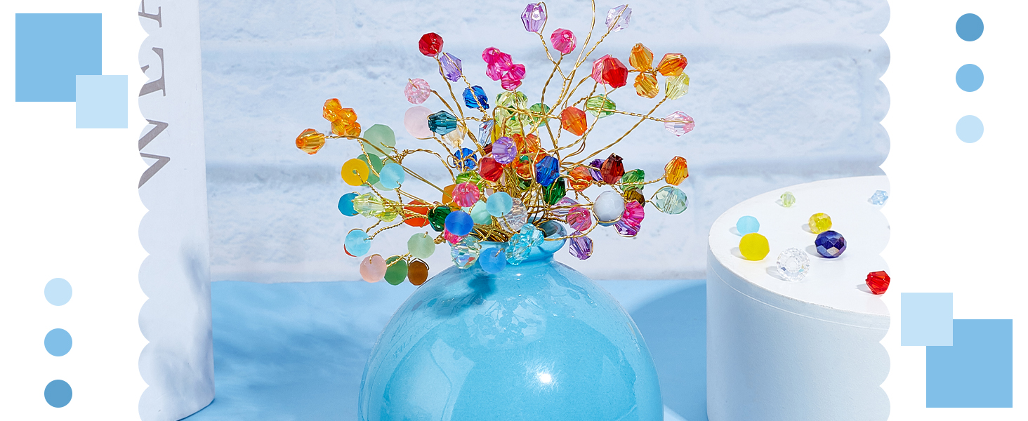Colorful crystal or beaded flower arrangement in light blue vase, featuring pink, yellow, and blue beads arranged in a spray pattern.