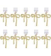 Multiple gold-toned bow and key charms arranged in rows, showing consistent decorative pattern.