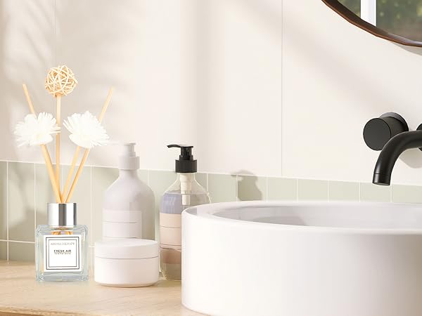 White minimalist home decor setting with decorative items including a pump bottle, light-up decorative elements, and white ceramic accessories.