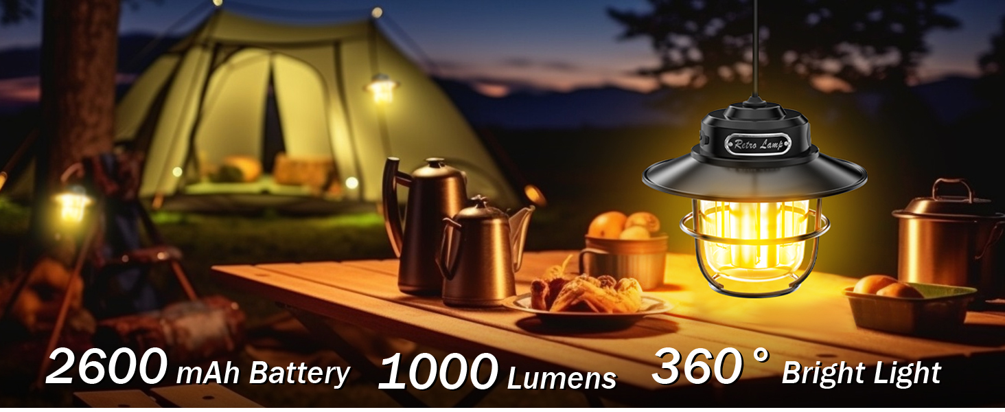 Portable camping lantern with 2600mAh battery, 1000 lumens brightness, and 360° light distribution. Illuminates campsite table with tent visible in background at dusk.