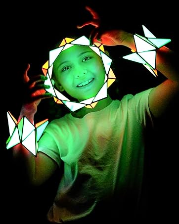 Girl holding and wearing TOSY Magnet Pyramids glowing in the dark in different shapes