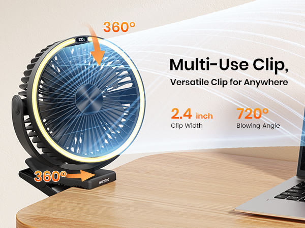 Black clip-on desk fan with 360° rotation, placed on a wooden desk beside a laptop.