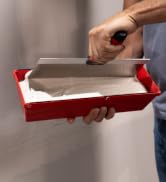 027-002 Plastic Mud Pan in a drywallers hand, being used to hold drywall mud