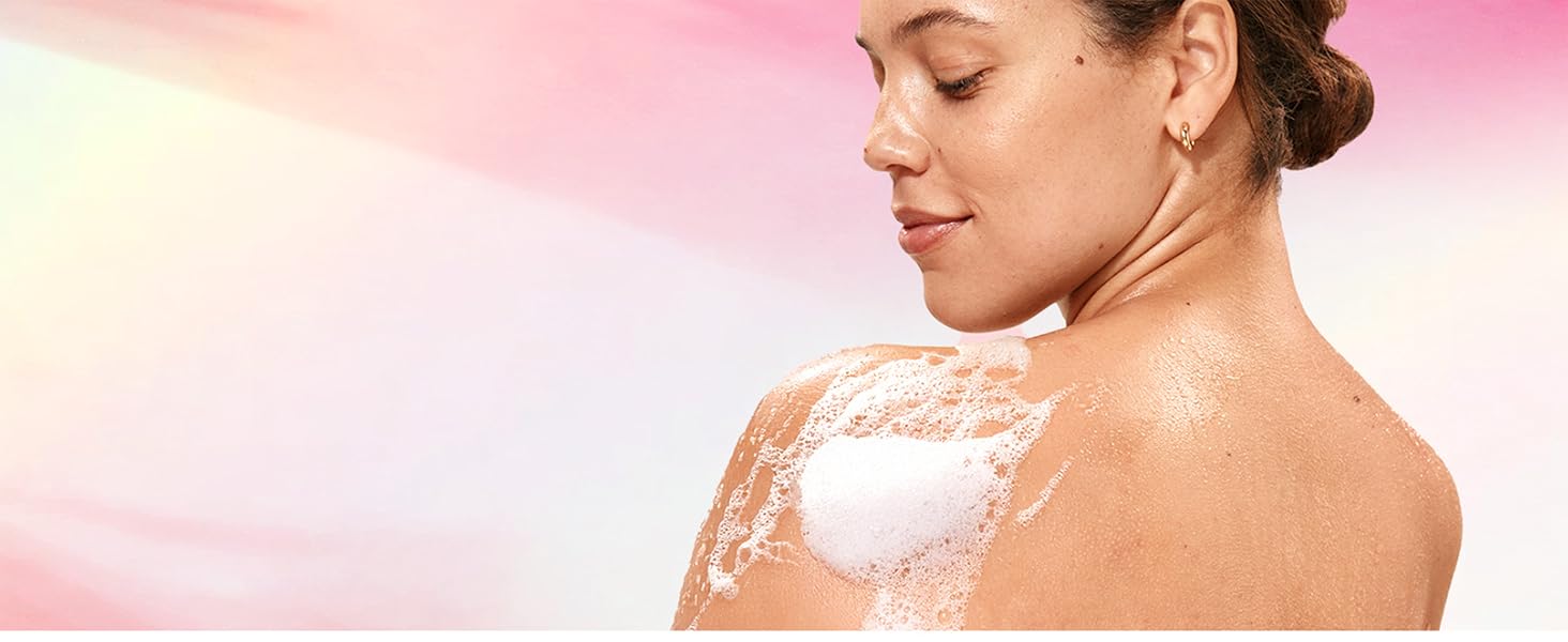 Woman covered in foam in front of a pink background